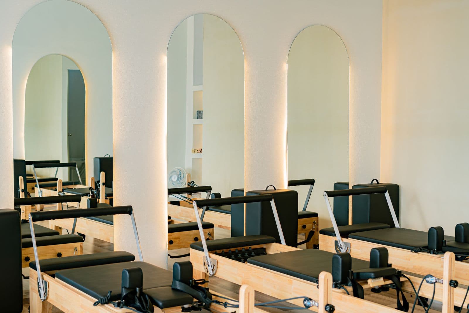 A bright, modern Pilates studio with reformer equipment